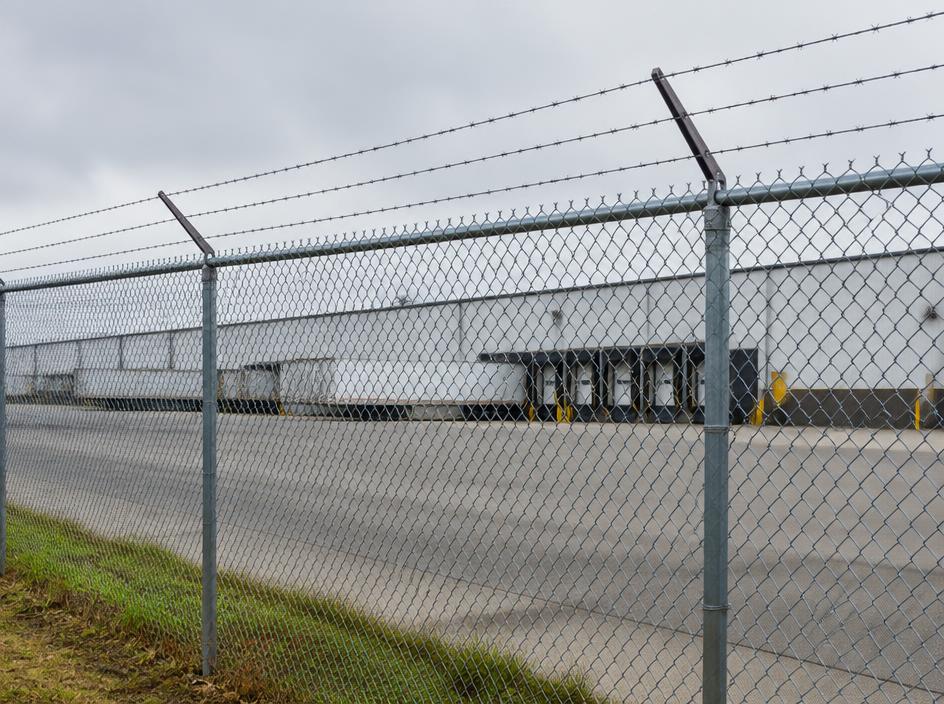 Commercial security chain link fence with barbed wire around a business lot